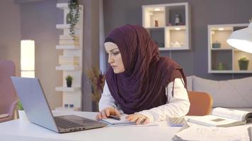 musulmano attività commerciale donna nel hijab gioisce. attività commerciale donna Lavorando nel casa ufficio è guardare a il computer portatile e gioisce ottenere bene notizia. video