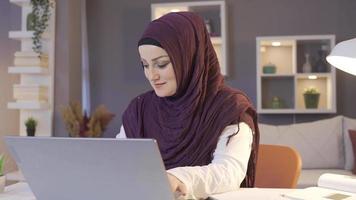 femme dans hijab à la recherche à portable et souriant. musulman femme dans hijab à la recherche à portable à Accueil est heureux. video