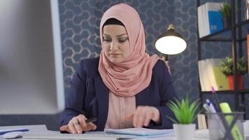 en företag kvinna i hijab Arbetar i en skynda, hon behov till skaffa sig saker Gjort. mycket upptagen muslim företag kvinna rör sig snabb i kontor. video