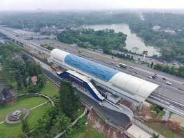 aerial view of an LRT station under construction, above the expressway and next to a park. photo