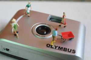 Bogor, Indonesia - Dec, 19 2022. miniature figures of a group of farmers working above an analog camera. photo