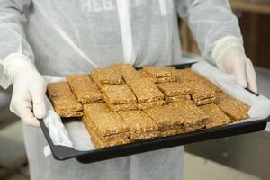 Assortment of cereal or protein bars that leave the assembly line at the factory. Healthy pre or post workout snacks with fruits, nuts and berries. photo