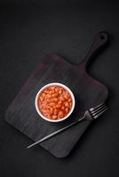 Delicious canned beans in a tomato in a white ceramic bowl photo