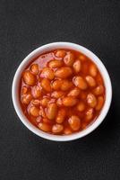 Delicious canned beans in a tomato in a white ceramic bowl photo