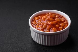 Delicious canned beans in a tomato in a white ceramic bowl photo