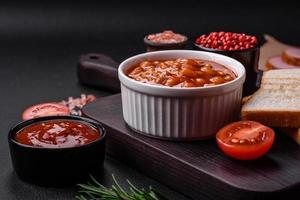 Delicious canned beans in a tomato in a white ceramic bowl photo