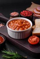 Delicious canned beans in a tomato in a white ceramic bowl photo