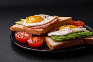 delicioso nutritivo Inglés desayuno con frito huevos, Tomates y aguacate foto