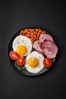 Delicious nutritious English breakfast with fried eggs and tomatoes photo