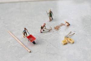 miniature figures of workers working together to move grain. photo