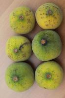 greenish yellow harp fruit isolated on money table has sweet and sour taste. Food concept photo. photo