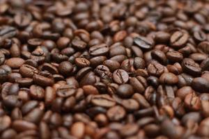 Detailed photo of coffee beans before being processed into a drink isolated on wood. Concept photo of the basic ingredients of coffee drinks.