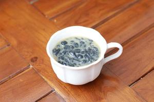 a close up of a glass of a traditional Indonesian drink called Dawet Ireng or black dawet. Indonesian traditional food photo concept.