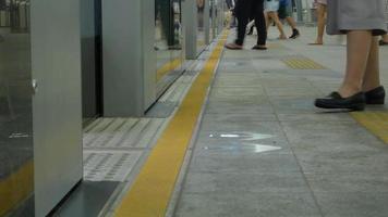 foot view to the train public transportation platform with many passenger waiting ready to board the train video