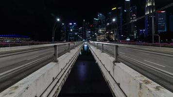 Timelapse trafik på de motorväg gata väg på bro över singapore marina bukt med bakgrund av stad metropol höghus skyskrapa byggnad horisont på natt tid video