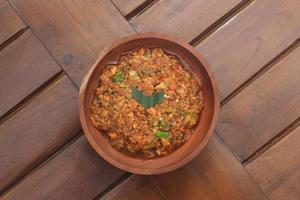 a close up Rujak Bebek or smashed fruit which is made from raw fruit crushed in a mortar and pestle and added with shrimp paste, chili and brown sugar. Indonesian traditional food photo concept.