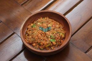 a close up Rujak Bebek or smashed fruit which is made from raw fruit crushed in a mortar and pestle and added with shrimp paste, chili and brown sugar. Indonesian traditional food photo concept.
