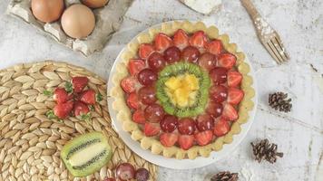 grande Fruta tarta con coberturas de fresas, uvas, kiwi y piña. sabroso, dulce y fresco. comida concepto foto. foto