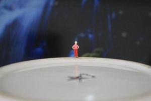 miniature figure of a child looking up at the mountains made of a plate and some cakes. photo