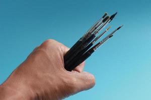 a close up of a hand holding a painting brush photo