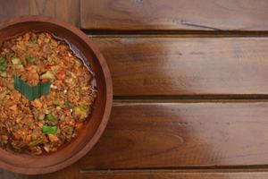 a close up Rujak Bebek or smashed fruit which is made from raw fruit crushed in a mortar and pestle and added with shrimp paste, chili and brown sugar. Indonesian traditional food photo concept.