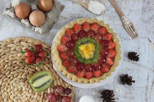 grande Fruta tarta con coberturas de fresas, uvas, kiwi y piña. sabroso, dulce y fresco. comida concepto foto. foto