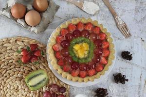 big fruit pie with toppings of strawberries, grapes, kiwi and pineapple. savory, sweet and fresh. Food concept photo. photo