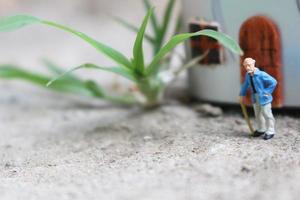 miniature figure of a grandfather who is waiting in front of the house. photo