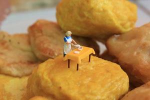 miniature figure of a mother cooking on yellow tofu. photo