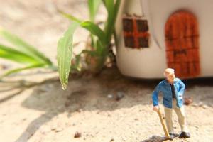 miniatura figura de un abuelo quien es esperando en frente de el casa. foto