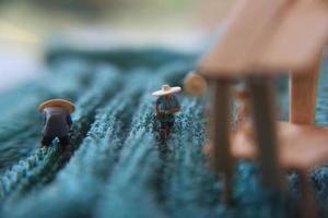 a photo of a miniature figure with the concept of a tea garden farmer who is harvesting, then a women waiting at the pavilion.