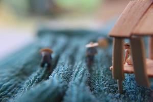 a photo of a miniature figure with the concept of a tea garden farmer who is harvesting, then a women waiting at the pavilion.