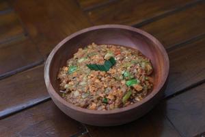 a close up Rujak Bebek or smashed fruit which is made from raw fruit crushed in a mortar and pestle and added with shrimp paste, chili and brown sugar. Indonesian traditional food photo concept.