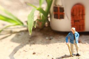 miniatura figura de un abuelo quien es esperando en frente de el casa. foto