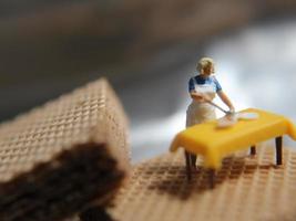 a miniature figure of a woman cooking on a chocolate wafer. photo