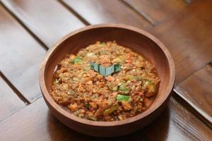 a close up Rujak Bebek or smashed fruit which is made from raw fruit crushed in a mortar and pestle and added with shrimp paste, chili and brown sugar. Indonesian traditional food photo concept.