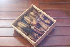 a close up of steamed bananas served on a woven bamboo container. photo