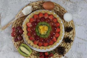 big fruit pie with toppings of strawberries, grapes, kiwi and pineapple. savory, sweet and fresh. Food concept photo. photo