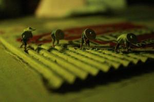 a close up of miniature figures of farmers who are farming on cardboard pieces like rice fields. farmer farming concept. photo