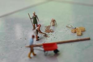 miniatura cifras de trabajadores trabajando juntos a moverse grano. foto