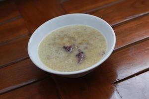 a close up of a bowl of green bean porridge and black sticky rice doused in coconut milk photo