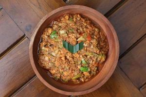 a close up Rujak Bebek or smashed fruit which is made from raw fruit crushed in a mortar and pestle and added with shrimp paste, chili and brown sugar. Indonesian traditional food photo concept.