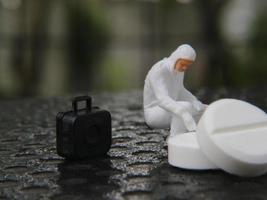 a close up of a miniature figure of a researcher researching a drug. health photo concept.