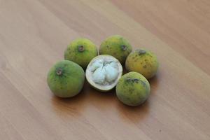 greenish yellow harp fruit isolated on money table has sweet and sour taste. Food concept photo. photo