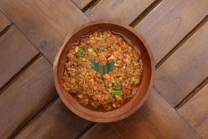 a close up Rujak Bebek or smashed fruit which is made from raw fruit crushed in a mortar and pestle and added with shrimp paste, chili and brown sugar. Indonesian traditional food photo concept.