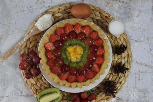 big fruit pie with toppings of strawberries, grapes, kiwi and pineapple. savory, sweet and fresh. Food concept photo. photo