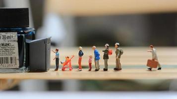 miniature figures of people queuing for public toilets. the concept of social etiquette. photo