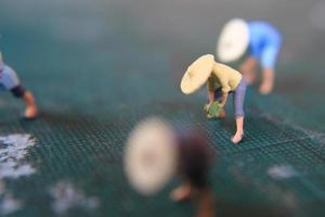 miniature figures of farmers working on a cutting mat. concept of agriculture photo. photo