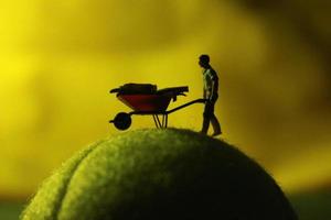 miniature figure of a female farmer working the land with a sunrise background. photo