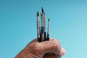 a close up of a hand holding a painting brush photo